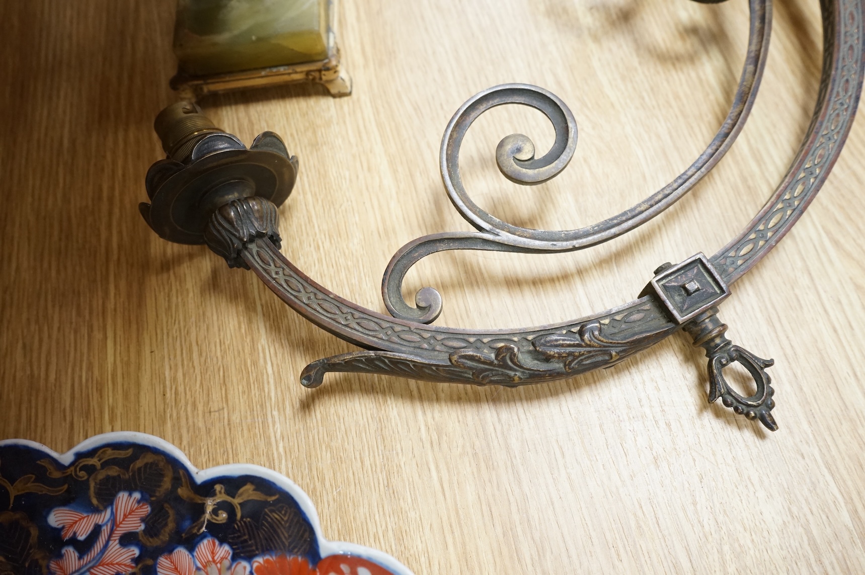 A cast brass wall sconce and a toleware two light lamp on onyx base, largest 46cm wide (2)